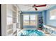 Cozy bedroom with a ceiling fan, a large window offering a view, and a stylish blue accent rug at 4900 Brittany S Dr # 1011, St Petersburg, FL 33715