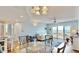 Open-concept living space features glass dining table and sliding glass doors to balcony with water view at 4900 Brittany S Dr # 1011, St Petersburg, FL 33715