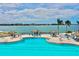 Community pool area with palm trees and lounging areas on a waterfront at 4900 Brittany S Dr # 1011, St Petersburg, FL 33715