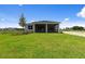 Home with a well-maintained backyard featuring a screen-enclosed patio and verdant lawn at 6982 Minneola Ct, Nokomis, FL 34275