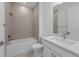 Modern bathroom features a tiled shower, tub, white vanity with sink, and large mirror at 6982 Minneola Ct, Nokomis, FL 34275