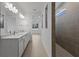 Large bathroom with double vanity, walk-in shower, and neutral tile at 6982 Minneola Ct, Nokomis, FL 34275