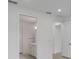 Hallway view of the bathroom features tile floors and white trim at 6982 Minneola Ct, Nokomis, FL 34275
