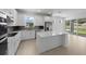 Bright kitchen featuring an island, stainless steel appliances, and sliding glass doors to the backyard at 6982 Minneola Ct, Nokomis, FL 34275