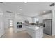 Well-lit kitchen with sleek white cabinetry, stainless steel appliances, and a center island at 6982 Minneola Ct, Nokomis, FL 34275