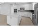 Spacious kitchen with white cabinetry, stainless steel appliances, and a center island, perfect for entertaining at 6982 Minneola Ct, Nokomis, FL 34275