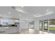 Bright, open-concept living room features white cabinets, stainless steel appliances, and sliding glass doors at 6982 Minneola Ct, Nokomis, FL 34275
