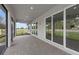 A screened patio that features stone flooring with views of a green yard and neighboring trees at 6982 Minneola Ct, Nokomis, FL 34275