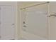 Bright bathroom features a tiled shower-tub combination with white tiled walls and a white door at 12218 Avondale Oak Pl, Riverview, FL 33578