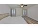 Bright bedroom with hardwood floors, a ceiling fan, and lots of natural light from dual windows at 12218 Avondale Oak Pl, Riverview, FL 33578
