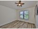 This bedroom has light walls, faux wood floors, and a ceiling fan and a window at 12218 Avondale Oak Pl, Riverview, FL 33578