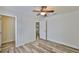 Bedroom with hardwood floors, a ceiling fan, neutral walls, and an open doorway at 12218 Avondale Oak Pl, Riverview, FL 33578