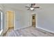 Bedroom featuring light walls, faux wood floors, ceiling fan, and doorways at 12218 Avondale Oak Pl, Riverview, FL 33578