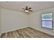 Cozy bedroom with light walls, wood-look flooring, and a ceiling fan at 12218 Avondale Oak Pl, Riverview, FL 33578