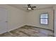 Bedroom featuring faux wood floors, light walls, a window, and ceiling fan at 12218 Avondale Oak Pl, Riverview, FL 33578