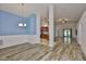Open-concept living space featuring wood floors, blue accent wall, and access to the kitchen at 12218 Avondale Oak Pl, Riverview, FL 33578