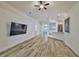 Bright living room with wood-look floors, open floor plan and mounted television at 12218 Avondale Oak Pl, Riverview, FL 33578