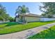 View of a well-maintained home with a lush green lawn and a pristine white fence at 12218 Avondale Oak Pl, Riverview, FL 33578