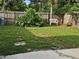 Grassy backyard features a white bench and lush greenery, offering a serene and private outdoor space at 1596 S Evergreen Ave, Clearwater, FL 33756
