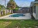 Backyard pool with concrete decking, surrounded by a privacy fence and lush greenery; perfect for relaxation at 1596 S Evergreen Ave, Clearwater, FL 33756