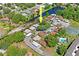 Aerial view of a neighborhood highlighting mature trees, a community pool and surrounding water at 1980 Tahitian Pl # 10, Dunedin, FL 34698