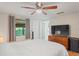The bedroom features hardwood floors, a ceiling fan, and large window with curtains at 1980 Tahitian Pl # 10, Dunedin, FL 34698