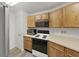 Kitchen with wooden cabinets and modern black and stainless steel appliances at 3964 Dream Oak Pl # 203, Tampa, FL 33613