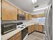 Kitchen featuring wooden cabinets, stainless steel sink, and modern appliances at 3964 Dream Oak Pl # 203, Tampa, FL 33613
