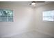 Light and airy bedroom featuring two windows, white walls, and a modern ceiling fan at 4720 Murray Hill Dr, Tampa, FL 33615
