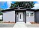Welcoming front entrance with a modern white door and gray exterior and fresh landscaping at 4720 Murray Hill Dr, Tampa, FL 33615