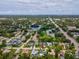 An aerial view showing a home with a green roof, surrounded by a lush, green neighborhood with a lake nearby at 5110 Lake Valencia E Blvd, Palm Harbor, FL 34684
