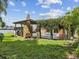 Expansive backyard with lush grass, a built-in grill, and a view of the pool at 5110 Lake Valencia E Blvd, Palm Harbor, FL 34684