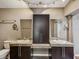 Bathroom with double sinks, granite countertops, and center storage unit with dark wood cabinetry at 5110 Lake Valencia E Blvd, Palm Harbor, FL 34684
