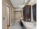 Modern bathroom featuring dual sinks, granite countertops, and a tiled walk-in shower at 5110 Lake Valencia E Blvd, Palm Harbor, FL 34684
