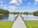 Community dock extending onto the neighborhood pond, with views of the surrounding homes at 5110 Lake Valencia E Blvd, Palm Harbor, FL 34684
