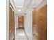 Hallway featuring white tiled floors, a closet, and a laundry area at 5110 Lake Valencia E Blvd, Palm Harbor, FL 34684