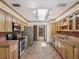 Spacious kitchen with stainless steel appliances, tile countertops, and a bright skylight at 5110 Lake Valencia E Blvd, Palm Harbor, FL 34684