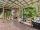 Outdoor brick patio with a built in fireplace and cooking area at 5110 Lake Valencia E Blvd, Palm Harbor, FL 34684