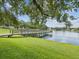 Picturesque view of the pond from a grassy bank, highlighting a tranquil waterside setting at 5110 Lake Valencia E Blvd, Palm Harbor, FL 34684