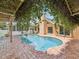 Tranquil in-ground pool with brick patio and view of the home's rear exterior at 5110 Lake Valencia E Blvd, Palm Harbor, FL 34684