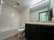 Well-lit bathroom featuring a tub and shower combination and a modern vanity with dark cabinets at 8819 Walnut Gable Ct, Riverview, FL 33578