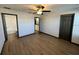 A modern bedroom with hardwood flooring and multiple entrances to other rooms at 8819 Walnut Gable Ct, Riverview, FL 33578