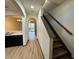 Hallway showcasing laminate floors, open archways, and access to the stairwell at 8819 Walnut Gable Ct, Riverview, FL 33578