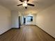 Open living area with laminate floors, ceiling fan, and modern arch to kitchen at 8819 Walnut Gable Ct, Riverview, FL 33578