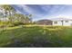 Expansive backyard featuring a large lawn, screened patio, and wooded area, perfect for outdoor activities and relaxation at 9016 Falcon Ct, Venice, FL 34293