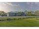 A beautifully landscaped home exterior showcases the lush green lawn, palm trees, and well-maintained gravel driveway at 9016 Falcon Ct, Venice, FL 34293
