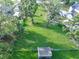 Scenic aerial view of a well-maintained lawn with mature trees, a shed, and a fenced perimeter, offering privacy at 10928 Echo Loop, New Port Richey, FL 34654