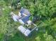 Aerial view of a home with a pool, outbuildings and lush greenery surrounding the property at 10928 Echo Loop, New Port Richey, FL 34654