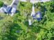 Aerial view of a home with a pool, outbuildings and lush greenery surrounding the property at 10928 Echo Loop, New Port Richey, FL 34654