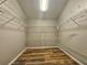 Walk-in closet with wood floors and multiple shelves for clothing and storage at 10928 Echo Loop, New Port Richey, FL 34654